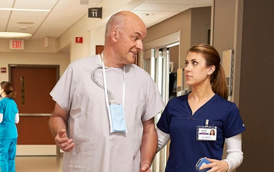 A man in scrubs talking to a woman in scrubs