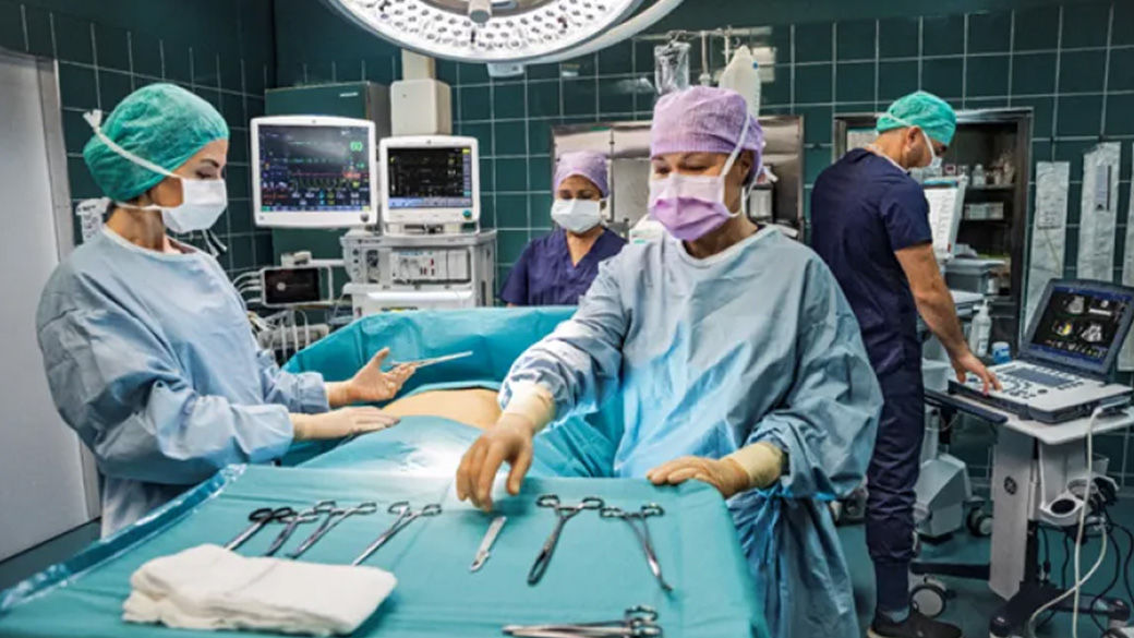 Operating room with four surgeons working on a patient