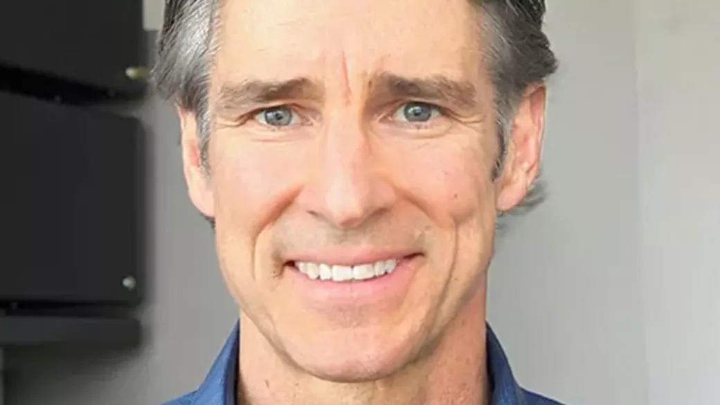Middle aged man with gray hair smiling and looking into the camera
