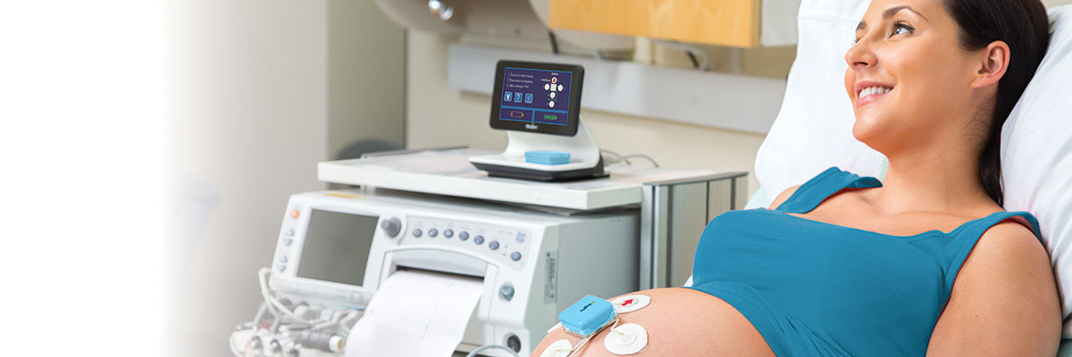 Nurse checking on an infant in a Giraffe Incubator Carestation