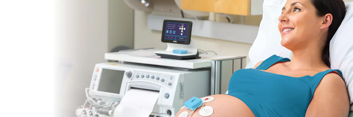 Nurse checking on an infant in a Giraffe Incubator Carestation