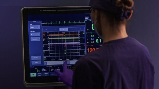 Clinician using CARESCAPE Canvas monitor on a bedside