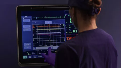 Clinician using CARESCAPE Canvas monitor on a bedside