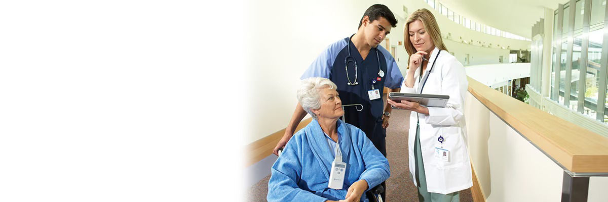 image of two medical staff discussing information with an elderly patient