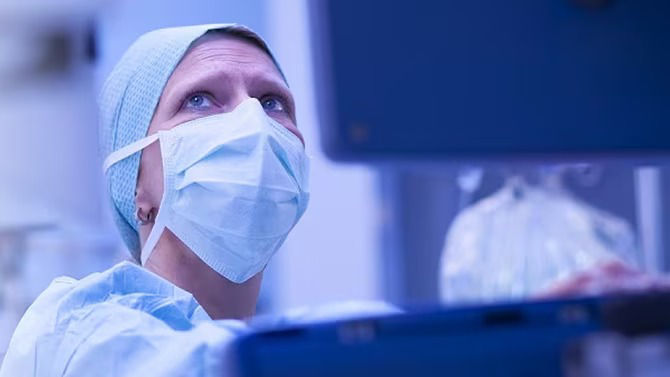 Health care provider wearing a mask looking up