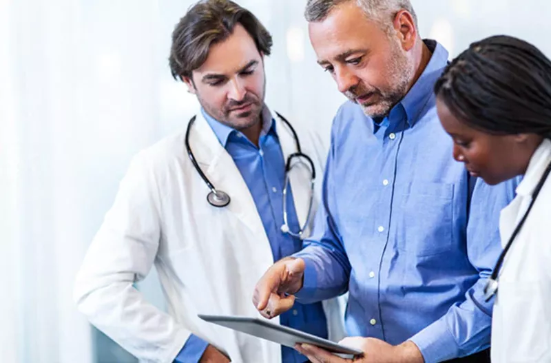 Three doctors looking at a tablet together