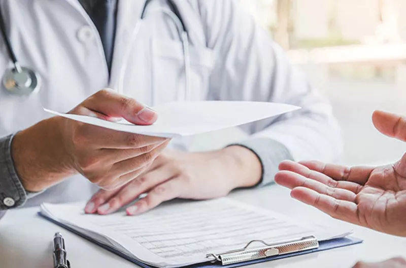 Doctor handing documents to another person
