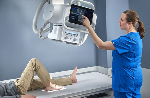 Definium656HD_Closeup 12 Year Old Boy Lying on Table for Foot, technologist interacting with screen for angulation