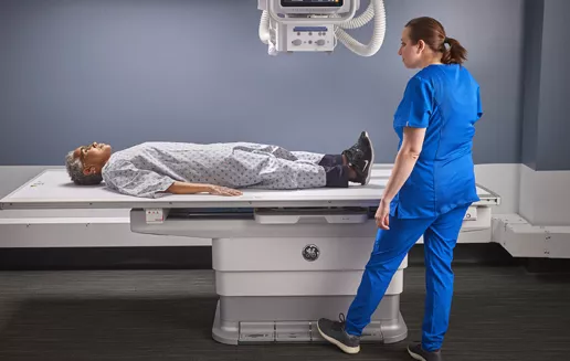 Elderly Woman Patient Lying on Table OTS Straight Down, Tech elevating Table