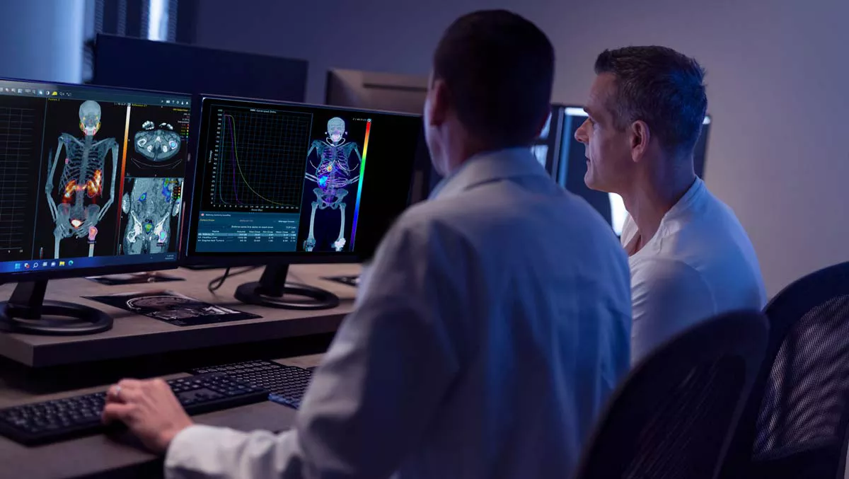 Two clinicans reviewing scans on screen