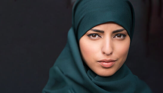 Woman faced directly at camera on black background