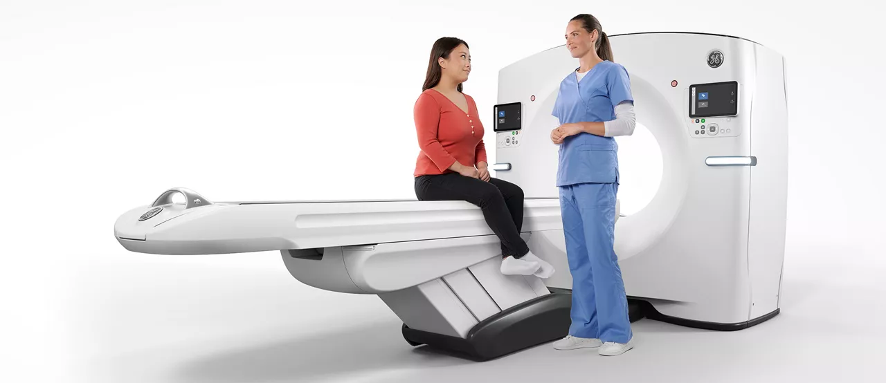Radiology tech with patient on table with CT gantry