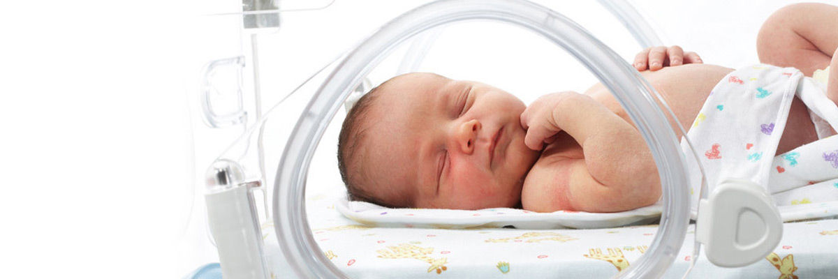 infant sleeping in a Giraffe warmer bed