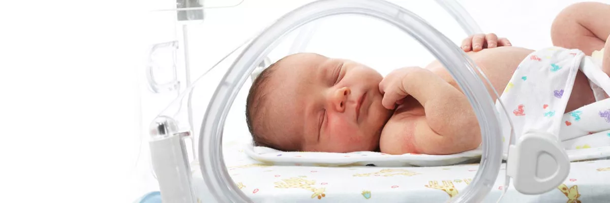 infant sleeping in a Giraffe warmer bed