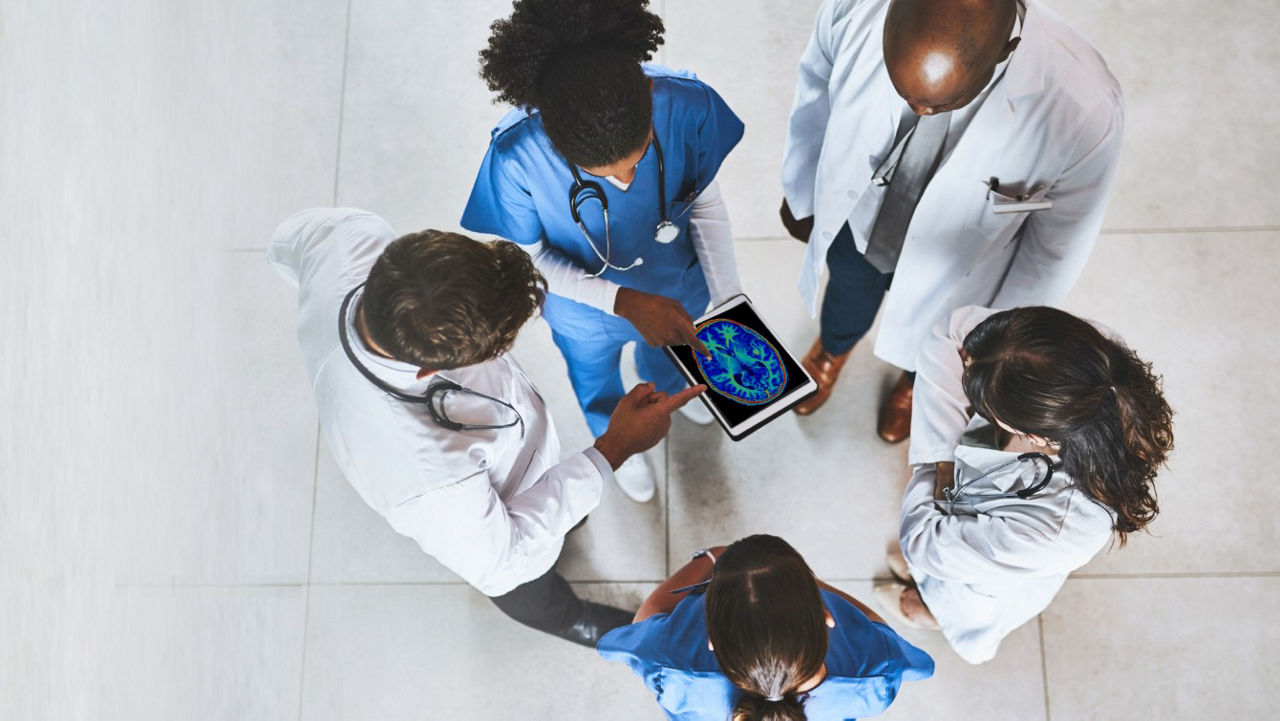 nurse looking at four giant monitors with analytis and patient vital signs