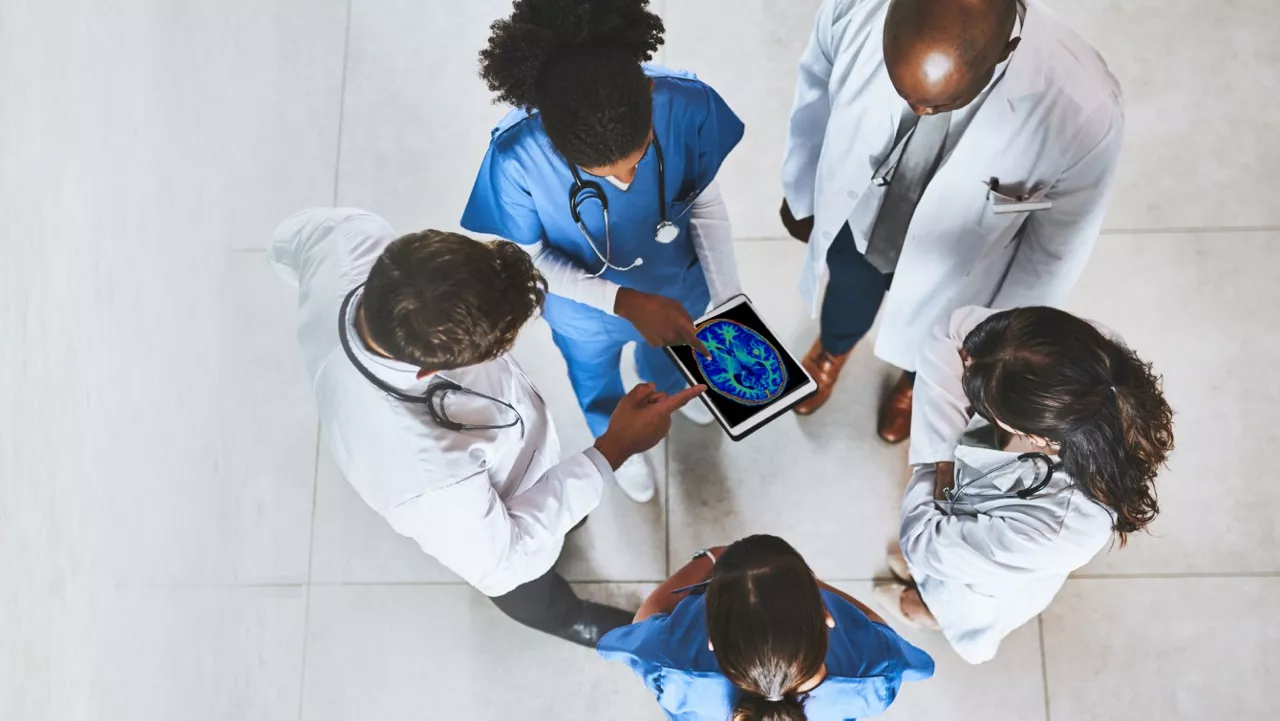 nurse looking at four giant monitors with analytis and patient vital signs