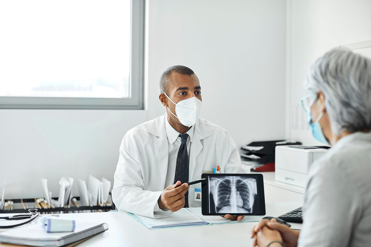 population-disease-and-care-doctor-explaining-woman-over-tablet-st-en