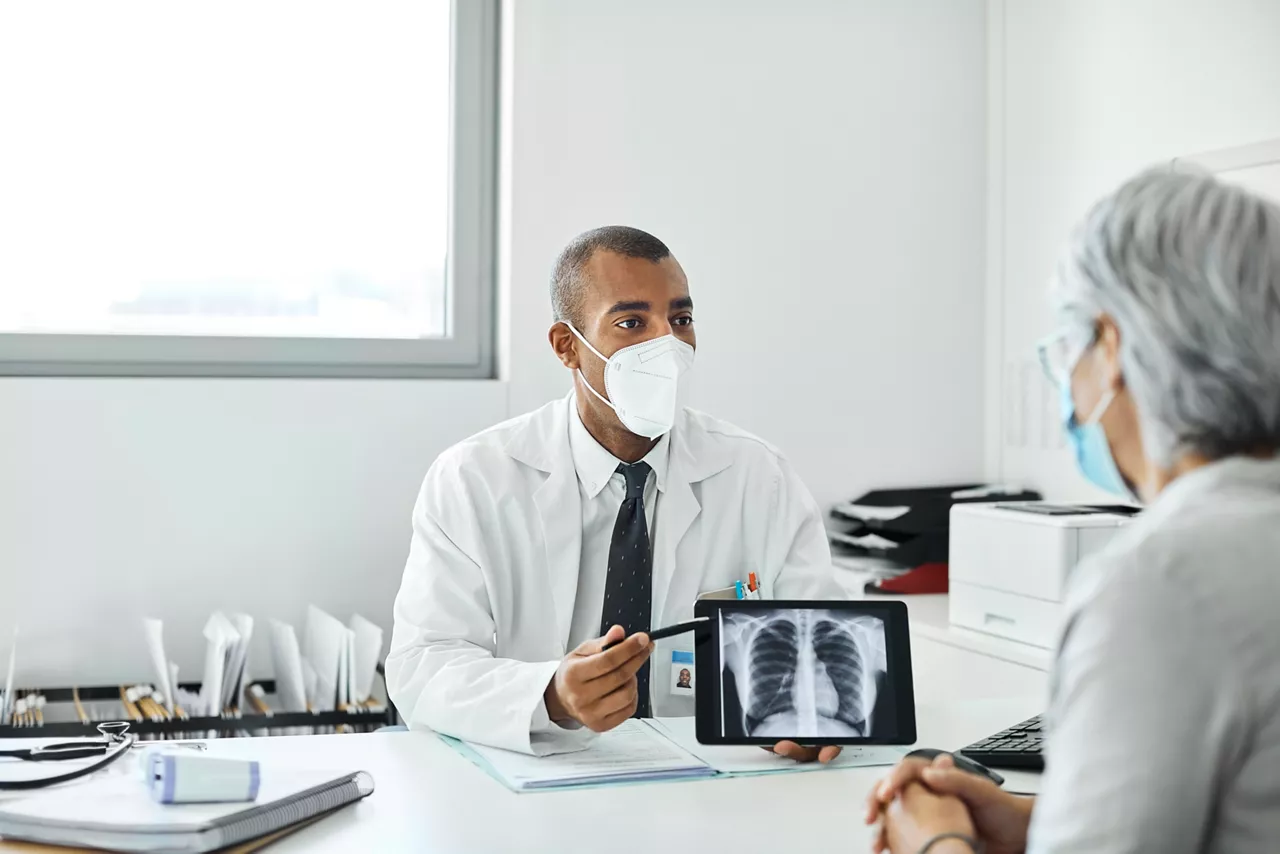 population-disease-and-care-doctor-explaining-woman-over-tablet-st-en
