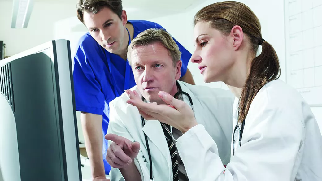 Clinicians collaborating at a computer.