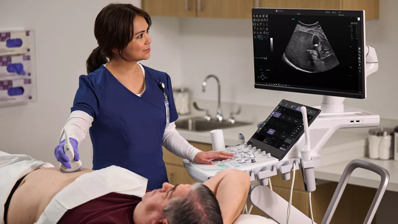Image showing woman physician in blue scrubs giving patient ultrasound