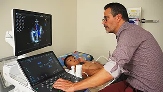 Image of male physician giving young boy a chest ultrasound