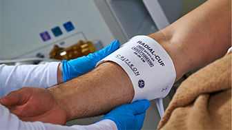 Clinician using a RADIAL-CUF blood pressure cuff on a patient's arm