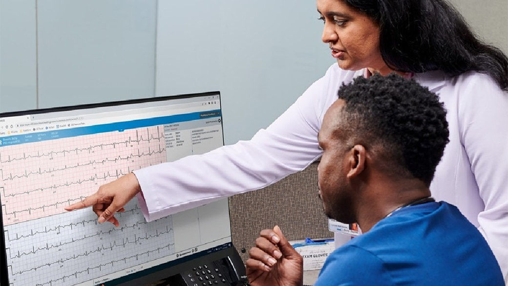 Clinicians reviewing medical results on a computer monitor.