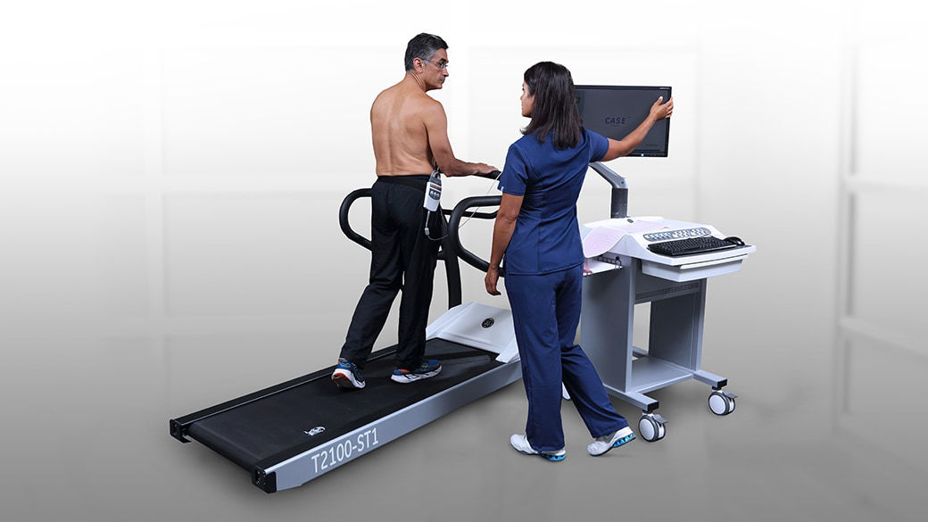 Patient walking on a treadmill in a medical setting.