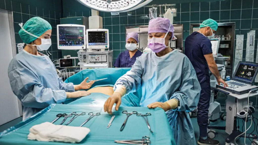 Operating room with four surgeons working on a patient