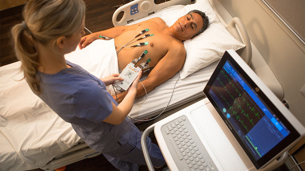 Clinician performing a resting ECG test on a patient with MAC VU360 system