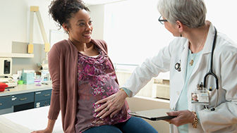 Clinician feeling pregnant woman's belly