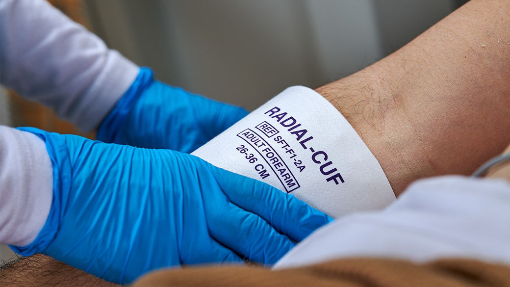 Clinician putting a blood pressure cuff on a patient.
