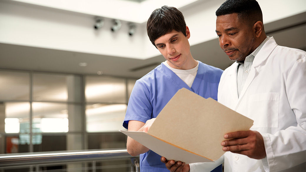 Two clinicians looking at a file