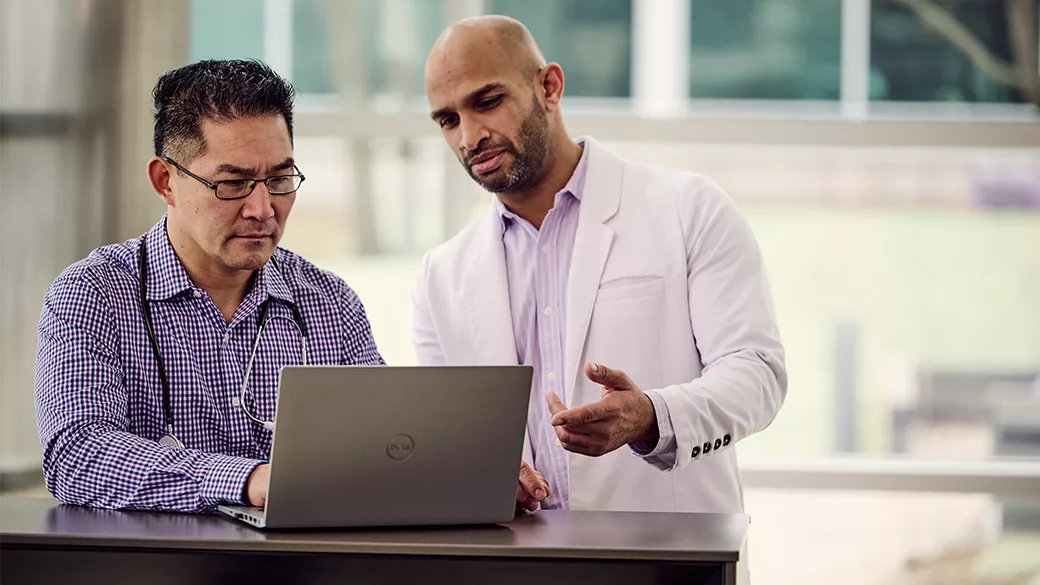 Two clinicians looking at a laptop