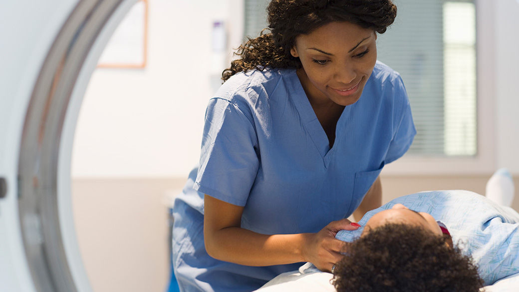 A clinician standing next to a patient being scanned