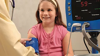 Pediatric patient having her blood pressure taken
