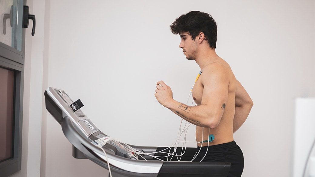 Patient running on a treadmill while hooked up to cardiac monitoring.