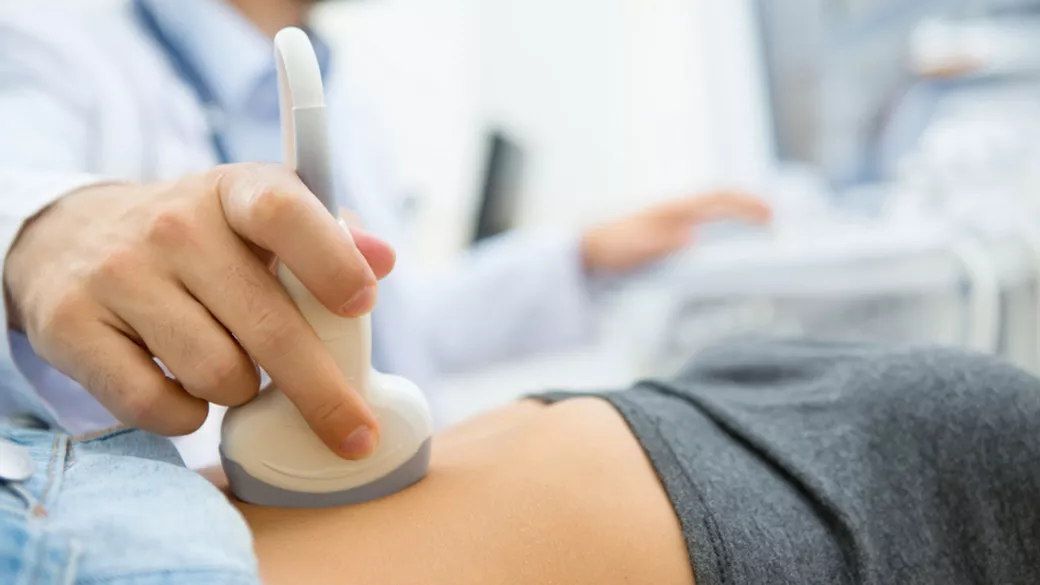 A clinician doing an ultrasound on a patient's stomach