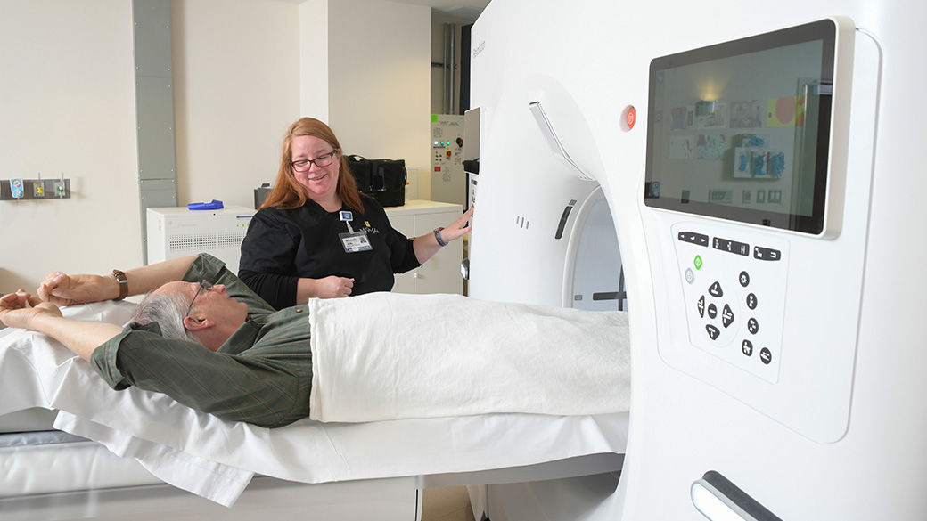 Clinician and patient getting ready for a CT scan.