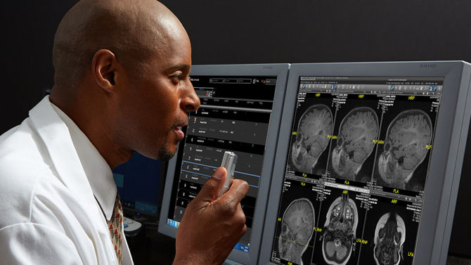 black radiologist dictating while reading exams