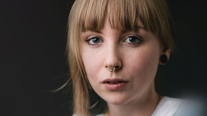 Woman faced directly at camera on pink background