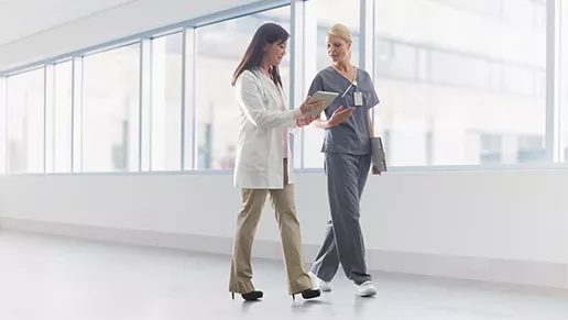Two clinicians walking a hallway.
