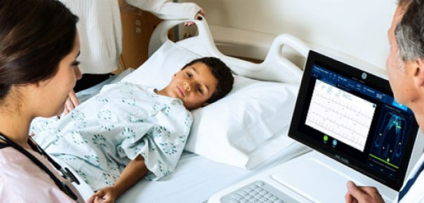 clinicians using diagnostic cardiology device with child patient