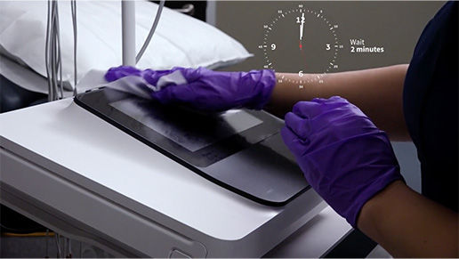 Gloved hands cleaning a touchscreen