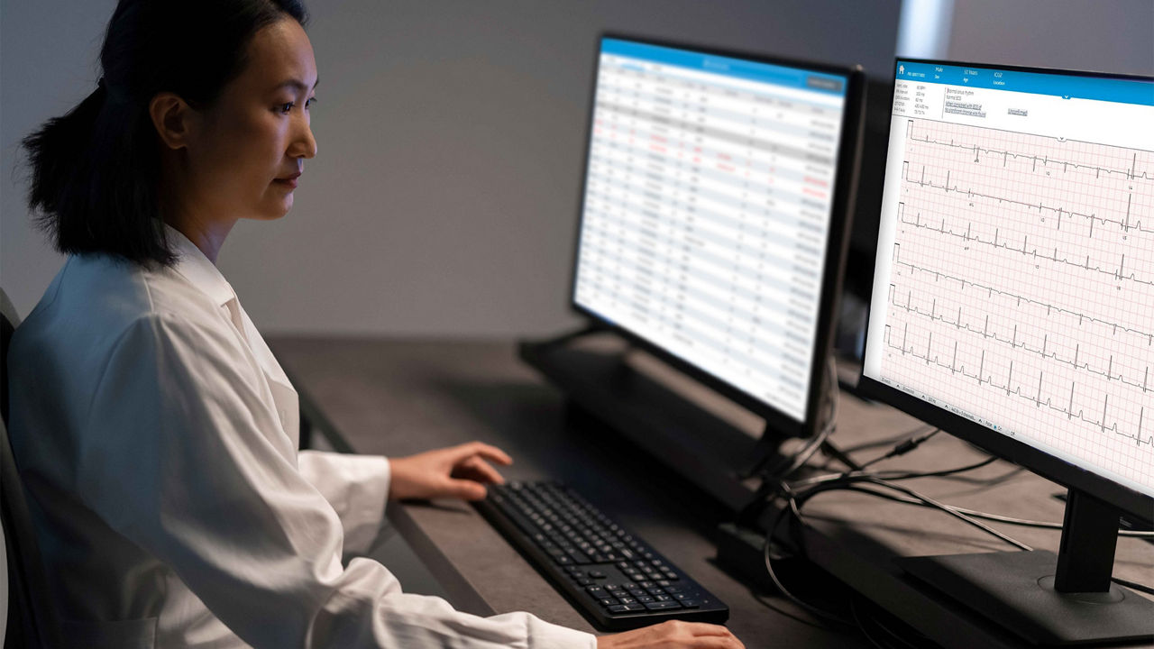 Clinician reviewing cardiac readings on a computer monitor.
