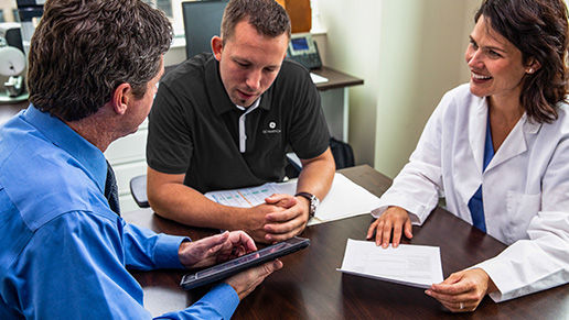 A physician and two business men chatting at a table