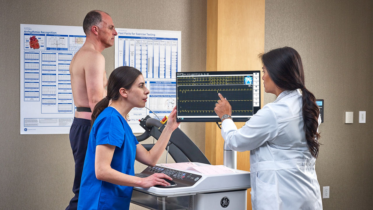 Clinicians assessing a walking patient's cardiac output.