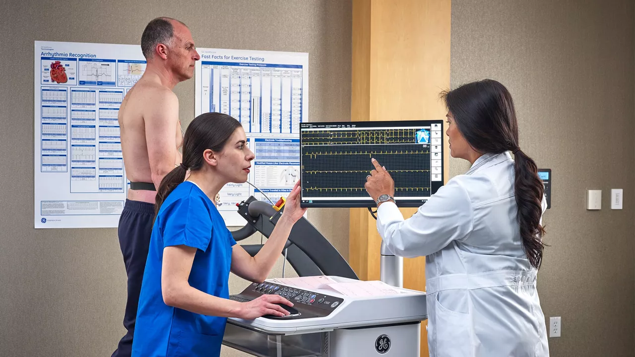 Clinicians assessing a walking patient's cardiac output.