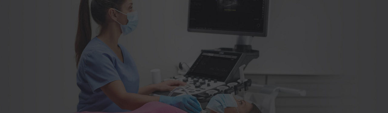 Clinician using an ultrasound machine on a patient