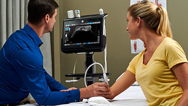 Doctor using a Venue Probe on a patient's arm in an exam room